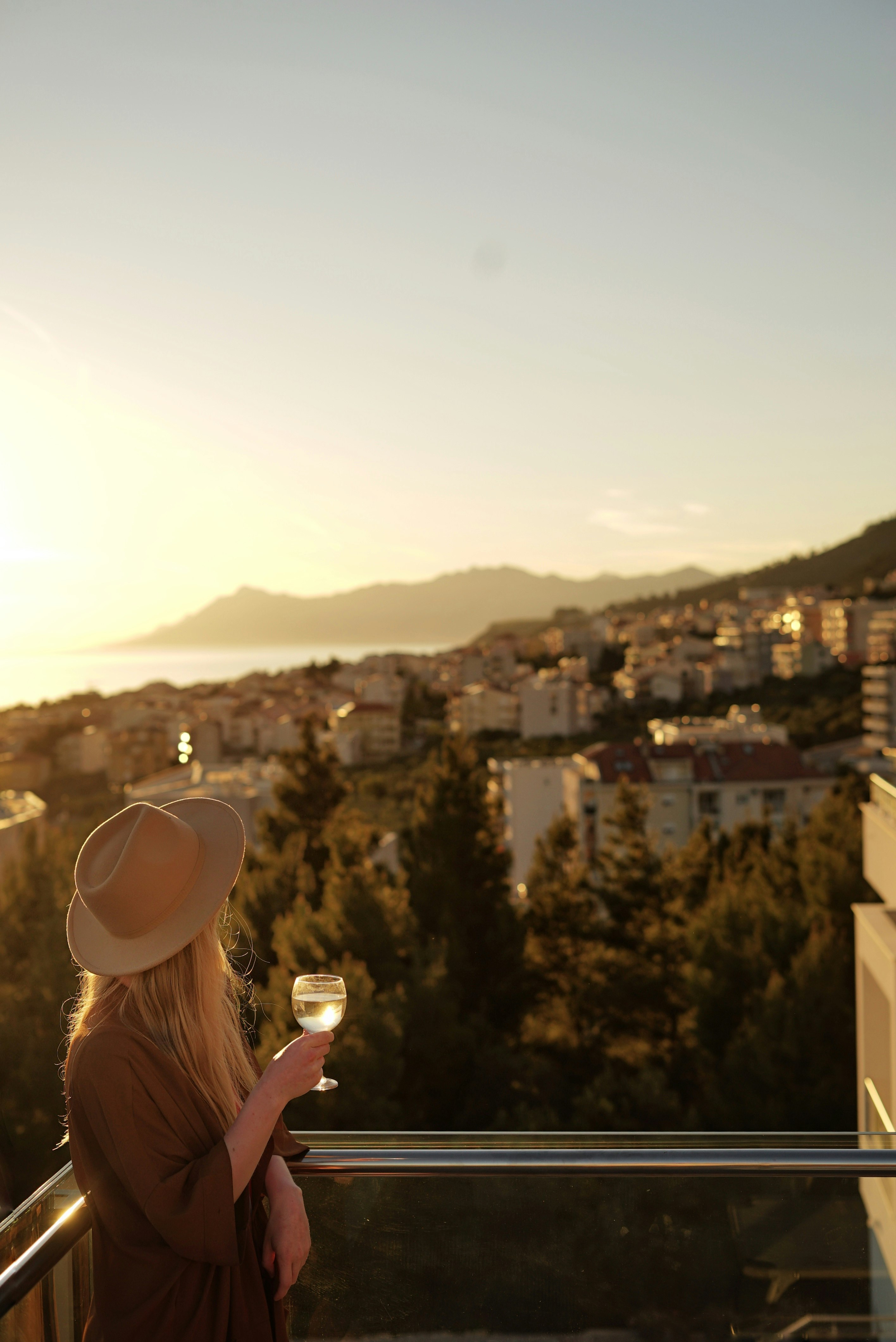 woman in white sun hat holding white ceramic mug